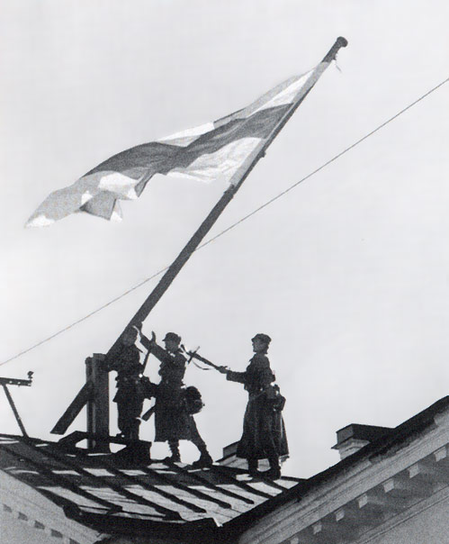 1. lokakuuta 1941. Ville Niemi, Mauri Valo ja Gunnar Segercrantz nostavat Suomen lipun hallintorakennuksen katolle